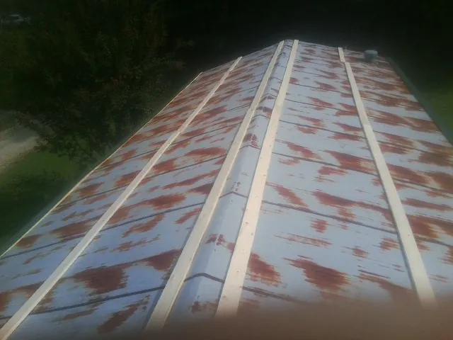 Rusted metal roof panels with new wood purlins before replacement — Storm Damage Roof Repair in Shakopee by Roofing Brothers